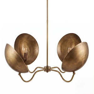 May include: A brass chandelier featuring a central vertical rod and four curved arms extending outward. Each arm supports a large, bowl-shaped shade with a brushed metallic finish. Two light bulbs are visible inside the concave brass shades.
