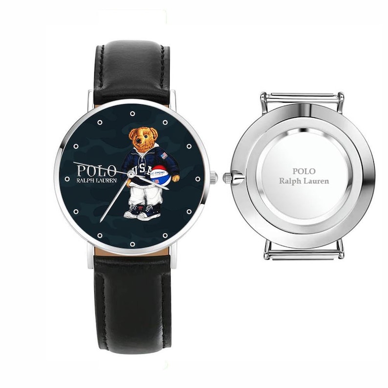 May include: A black leather strap watch with a navy blue face featuring a bear wearing a jacket and holding a ball. The watch face has the text "POLO" and "RALPH LAUREN". The watch also has a silver back with the text "POLO Ralph Lauren".