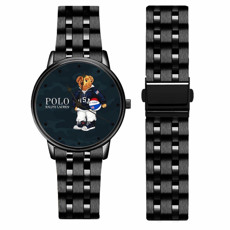 May include: Black wristwatch with a matching band. The watch face features a cartoon bear wearing a jacket and holding a basketball. The watch face has the words "POLO RALPH LAUREN" and a camouflage background.