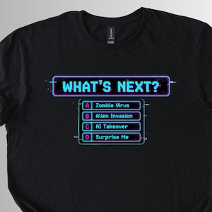 May include: Black t-shirt with the text "WHAT'S NEXT?" in a neon-style font. Below the text are four options: Zombie Virus, Alien Invasion, AI Takeover, and Surprise Me. The design has a retro video game aesthetic.