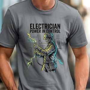 May include: Gray t-shirt with the text "ELECTRICIAN POWER IN CONTROL" above an illustration of an electrician holding electrical wires with lightning bolts. The electrician is wearing a hard hat and work belt.