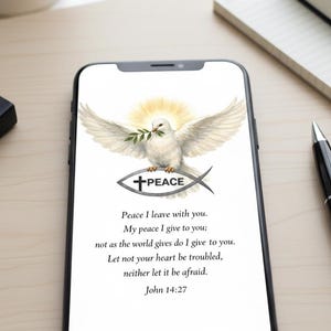 May include: A smartphone displays a digital image featuring a white dove with outstretched wings, holding an olive branch. Below the dove is a fish symbol with a cross and the word "PEACE." The image includes a Bible verse and the text "TiredButDesigned."