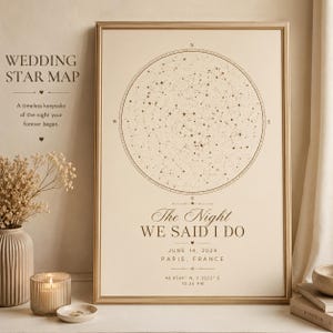 May include: A framed wedding star map print. The print features a circular star chart with the text "The Night We Said I Do" and the date June 14, 2024, along with the location Paris, France. The frame is gold.