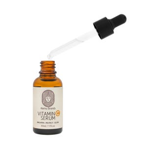 Op de afbeelding: Een bruine glazen fles vitamine C serum met een zwarte druppelaar. Het etiket luidt "Alemu Brands Vitamin C Serum" met de slogan "Brighten - Protect - Glow". De fles bevat 30 ml / 1 fl.oz.