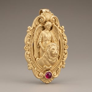 May include: Gold-colored pendant with an angel and lion design. The pendant has an oval shape with ornate scrollwork and a small, round, red gemstone at the bottom. The angel has wings and is standing behind the lion.