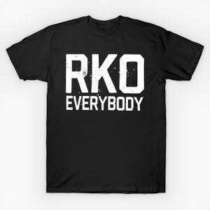Puede incluir: Camiseta negra con el texto blanco "RKO EVERYBODY" en una fuente desgastada y en bloques. La camiseta es de cuello redondo y el texto está centrado en la parte delantera.