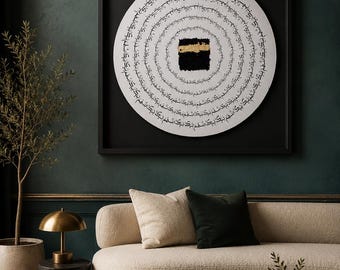 Puede incluir: Un marco cuadrado negro que contiene una obra de arte circular blanca con caligrafía árabe negra dispuesta en anillos concéntricos alrededor de un cuadrado central negro con una banda dorada texturizada.