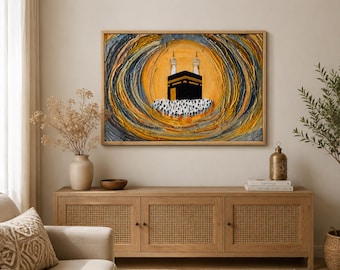 May include: An abstract painting of the Kaaba in Mecca, framed in a wooden border. The artwork features a black cube structure with two minarets, set against a yellow and swirling background with blue and orange tones. The painting is displayed above a wooden cabinet.