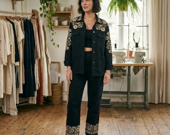 Conjunto de chaqueta y pantalón negro con bordado floral, elegante atuendo formal.