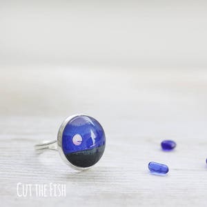 Anillo ajustable en tono plateado con luna llena azul