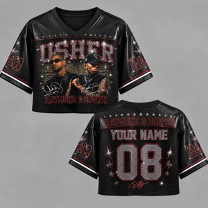 May include: A black V-neck crop top jersey featuring a graphic print of Usher and Chris Brown with the text USHER and RAYMOND & BROWN. The back displays the text YOUR NAME and the number 08 in a glittery font, accented with star patterns.