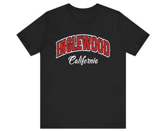 May include: Black t-shirt with the word "INGLEWOOD" in red, outlined in white, above the word "California" in white script. The shirt is a short-sleeved crew neck.
