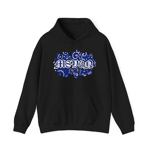 May include: Black hooded sweatshirt with a front pocket and drawstring. The sweatshirt features a blue and white paisley design with the text "MSV3A" in a stylized font, centered on the chest.