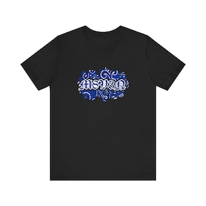 May include: Black t-shirt featuring a blue paisley design with the word "MSB3N" in white, stylized lettering. The design is centered on the front of the shirt. The shirt has short sleeves and a crew neck.