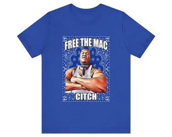 May include: Royal blue t-shirt featuring a graphic of a man with arms crossed, wearing a white tank top and a blue bandana. The text "FREE THE MAC" and "CITCH" are in white.