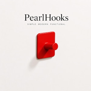 May include: A bright red wall hook with a square base and a cylindrical hook. The hook is mounted on a white wall. The text "PearlHooks" and "SIMPLE. MODERN. FUNCTIONAL." are displayed above the hook.