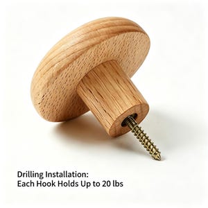 May include: A light-colored wooden wall hook with a circular head and a cylindrical base, featuring a metal screw protruding from the center. The text below states: Drilling Installation: Each Hook Holds Up to 20 lbs.