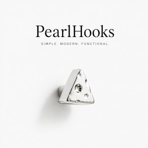 May include: A silver-coloured triangular wall hook with a textured, dimpled surface. The text PearlHooks SIMPLE. MODERN. FUNCTIONAL. is printed above the hook. The hook has a metallic finish and a three-sided geometric shape with rounded corners.