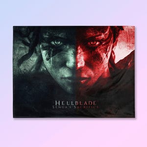 May include: A rectangular print featuring a split face portrait. One side is in shades of green and black, the other in red. The text "HELLBLADE SENUA'S SACRIFICE" is printed in white at the bottom.