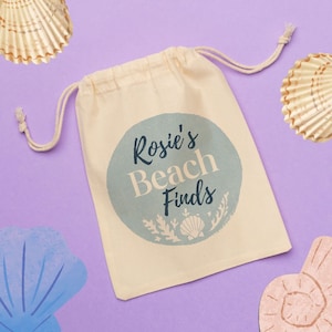 May include: A beige drawstring bag with a blue circle design that says "Rosie's Beach Finds".