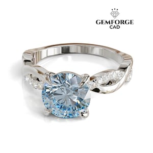 May include: A silver ring with a large, round, light blue gemstone as the centerpiece. The band has a twisted design with smaller, clear gemstones. The ring is set against a white background.
