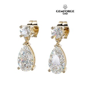 Peut inclure: Une paire de boucles d'oreilles pendantes dorées. Chaque boucle d'oreille présente une pierre précieuse ronde et transparente en haut et une pierre précieuse transparente en forme de poire suspendue en dessous. Les boucles d'oreilles sont sur fond blanc.