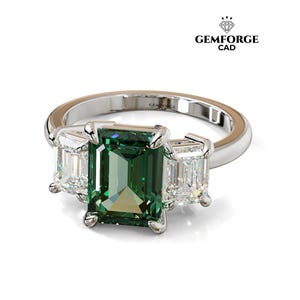 Puede incluir: Anillo plateado con una gran gema verde central de talla esmeralda y dos gemas blancas más pequeñas a cada lado. El anillo está sobre un fondo blanco. Se aprecia el logotipo de Gemforge CAD.