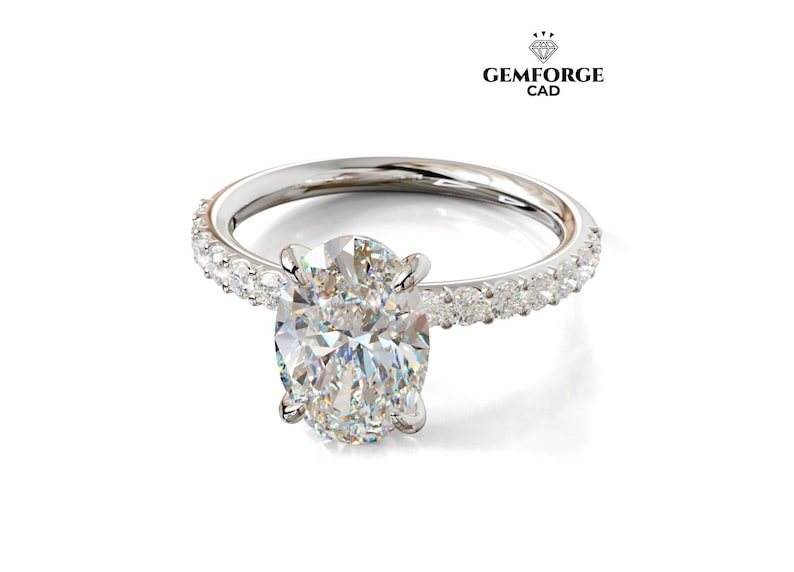 May include: A silver ring featuring an oval-cut diamond centre stone, surrounded by smaller diamonds set into the band. The Gemforge CAD logo is displayed in the top right corner.