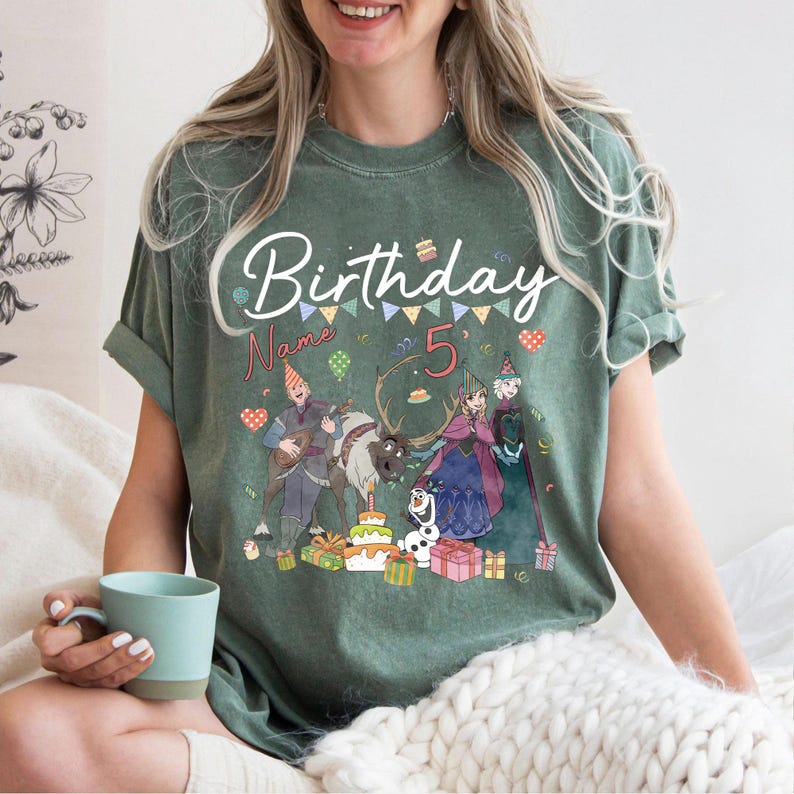 May include: Green t-shirt with a birthday theme. The shirt features the word "Birthday" in white script, the number "5", and cartoon characters. Colorful confetti and gift boxes are also visible on the shirt.