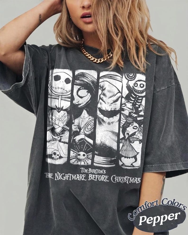 May include: A charcoal gray oversized t-shirt featuring a white graphic print of characters from Tim Burton's The Nightmare Before Christmas. The design includes four vertical panels with various figures, and the text reads Tim Burton's The Nightmare Before Christmas. The bottom corner includes the text Comfort Colors Pepper.