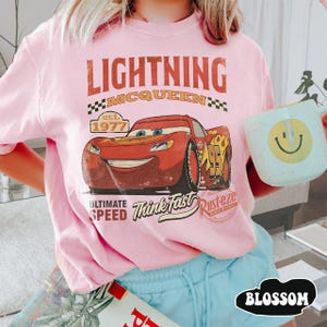 Puede incluir: Camiseta rosa con estampado de Rayo McQueen de la pel&iacute;cula Cars. El dise&ntilde;o incluye el texto "LIGHTNING MCQUEEN" y "Think Fast". La camiseta es de cuello redondo y manga corta. Dise&ntilde;o vintage.