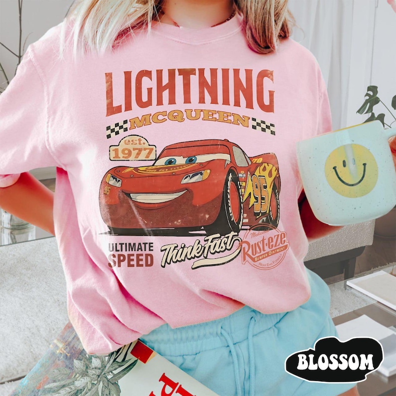 Puede incluir: Camiseta rosa con estampado de Rayo McQueen de la pel&iacute;cula Cars. El dise&ntilde;o incluye el texto "LIGHTNING MCQUEEN" y "Think Fast". La camiseta es de cuello redondo y manga corta. Dise&ntilde;o vintage.