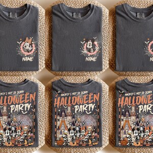 May include: Six dark gray t-shirts with Halloween-themed designs. Three shirts feature a Minnie Mouse design with a spiderweb and the word "NAME". The other three shirts display "Mickey's Not So Scary Halloween Party" with a castle and characters.