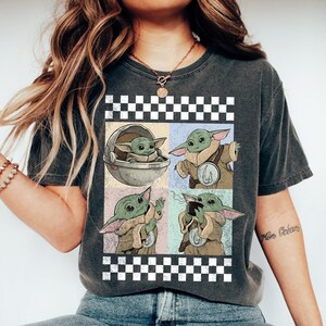 Puede incluir: Camiseta gris oscuro con un dise&ntilde;o gr&aacute;fico de cuatro paneles de Grogu de The Mandalorian. Los paneles muestran a Grogu en diferentes poses, incluyendo una en una c&aacute;psula y otra bebiendo de una taza. El dise&ntilde;o est&aacute; enmarcado por un patr&oacute;n de cuadros blanco y negro.