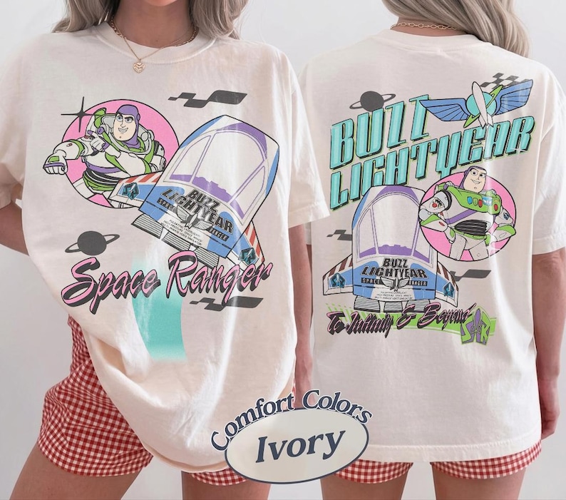 May include: An ivory t-shirt featuring Buzz Lightyear graphics. The front displays Buzz in a pink circle, a spaceship, and the text Space Ranger. The back shows the name Buzz Lightyear, a spaceship, Buzz in a circle, and To Infinity & Beyond.