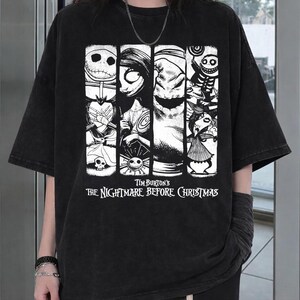 May include: A black short-sleeve t-shirt featuring a white graphic print of characters from Tim Burton's The Nightmare Before Christmas. The design includes four vertical panels with illustrations of Jack Skellington, Sally, and Oogie Boogie.