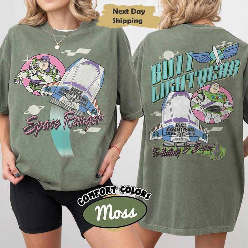 May include: A moss green t-shirt featuring Buzz Lightyear graphics on the front and back. The front displays Buzz Lightyear, a spaceship, and the text Space Ranger. The back shows Buzz Lightyear, a spaceship, and the text Buzz Lightyear To Infinity & Beyond.