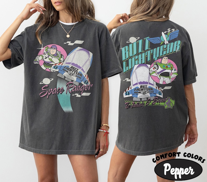 May include: A charcoal gray short-sleeve t-shirt featuring Buzz Lightyear graphics. The front displays Buzz Lightyear, a spaceship, and the text Space Ranger. The back shows Buzz Lightyear, a spaceship, and the text Buzz Lightyear To Infinity & Beyond.