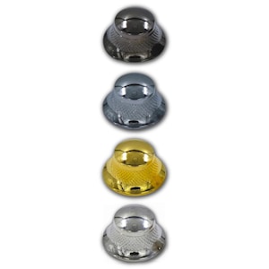 May include: A set of four dome-shaped control knobs for musical instruments or audio equipment. Each knob features a smooth, rounded top and a textured, knurled side surface. The set includes one black, one dark chrome, one gold, and one silver knob.