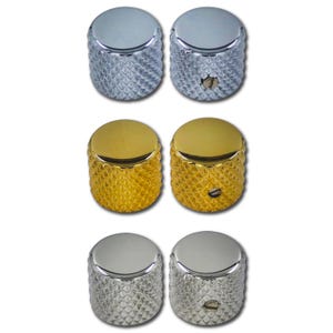 May include: A collection of six guitar knobs in silver and gold. The knobs have a textured, diamond-patterned grip and a smooth, rounded top. The silver knobs are on the top and bottom, while the gold knobs are in the middle.