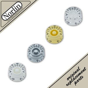 May include: Four circular Norlin control knobs for musical instruments, arranged diagonally. Each knob features black numerical markings from 0 to 10. The set includes one clear, one cream, one silver-topped, and one white knob, all with a central post.