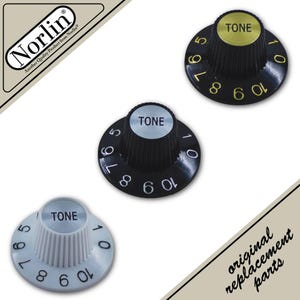 May include: Three guitar tone control knobs featuring a ribbed exterior and numbered scale from 0 to 10. One knob is white with silver top, one is black with silver top, and one is black with gold top. Text Norlin and original replacement parts.