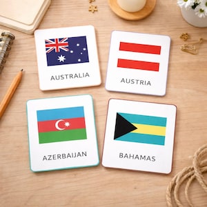 Può includere: Quattro sottobicchieri quadrati con le bandiere di Australia, Austria, Azerbaigian e Bahamas. Ogni sottobicchiere mostra la bandiera e il nome del paese. Sono disposti su una superficie di legno.