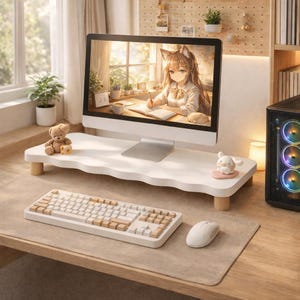 May include: A white, wavy-edged monitor stand with wooden legs supports a computer monitor displaying an anime-style illustration. A white keyboard and mouse sit on a beige desk mat. A teddy bear and a small figurine are on the stand.