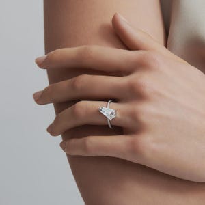 Contemporary solitaire engagement ring featuring a kite cut center diamond and pavé details