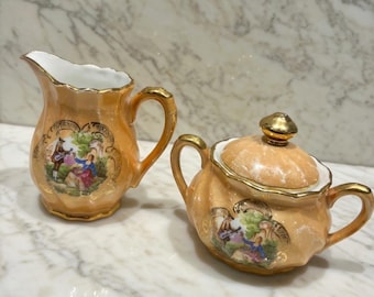 Set vintage tedesco in porcellana con zuccheriera e lattiera, raffigurante una coppia di innamorati, con dettagli in oro 22 carati, proveniente dalla Baviera.