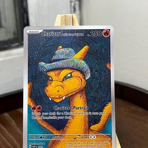 Op de afbeelding: Een Pokémon-kaart met Charizard met een grijze vilten hoed. De kaart toont een oranje Charizard met groene ogen, met een grijze hoed, tegen een sterrenachtergrond. Tekst: "Charizard with Grey Felt Hat" en "Charizard-Portrait".