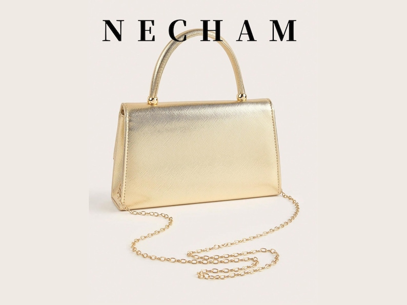 May include: A gold-colored handbag with a top handle and a chain strap. The rectangular bag has a metallic finish and the brand name "NECHAM" is printed at the top.
