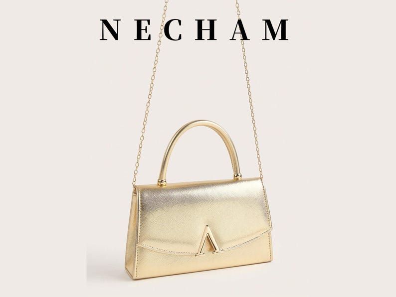 May include: A gold-colored handbag with a top handle and a chain strap. The bag has a rectangular shape with a flap closure and a gold-colored V-shaped detail on the front. The word "NECHAM" is displayed above the bag.