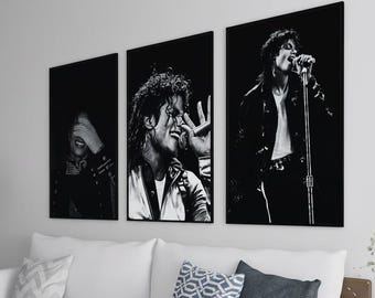 Puede incluir: Un salón con tres obras de arte enmarcadas en blanco y negro que representan a un cantante en varias poses. Las obras de arte cuelgan sobre un sofá blanco con cojines decorativos. Una lámpara de pie negra y una mesa auxiliar completan la decoración.